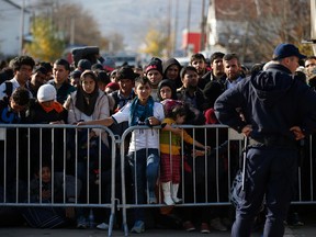 Migrants wait to register with the police at the refugee center in the southern Serbian town of Presevo, Monday, Nov. 16, 2015. Refugees fleeing war by the tens of thousands fear the Paris attacks could prompt Europe to close its doors, especially after police said a Syrian passport found next to one attacker’s body suggested its owner passed through Greece into the European Union and on through Macedonia and Serbia last month. (AP Photo/Darko Vojinovic)