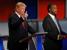 Republican U.S. presidential candidate businessman Donald Trump gives a thumbs up as he stands next to Dr. Ben Carson (R) at the start of the debate for the top 2016 U.S. Republican presidential candidates on November 10, 2015. In the U.S. the Paris attacks should be a wake-up call for voters.  REUTERS/Jim Young