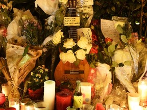 This photo taken on November 16, 2015 shows flowers, candles, messages and various objects left at a makeshift memorial next to the Bataclan concert hall in Paris. (AFP PHOTO)