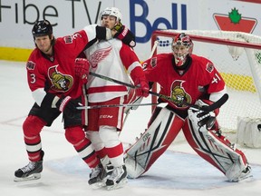 Ottawa Senators defenseman Marc Methot ties up Detroit Red Wings left wing Tomas Tatar in front of goalie Craig Anderson during third period NHL action Monday, November 16, 2015 in Ottawa. The Red Wings defeated the Senators 4-3 in overtime. THE CANADIAN PRESS/Adrian Wyld