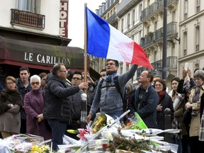 People pay tribute to victims outside Le Carillon restaurant, one of the attack sites in Paris, November 16, 2015. REUTERS/Pascal Rossign