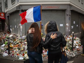 Two women stand outside the Petit Cambodge restaurant, a site of last Friday's attacks, in Paris, on Nov. 17, 2015. (AP Photo/Daniel Ochoa de Olza)