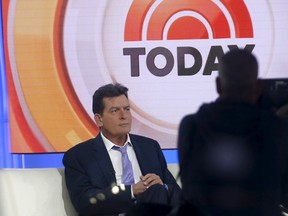 Actor Charlie Sheen is seen through a window as he sits on the set of the NBC Today show prior to being interviewed by host Matt Lauer in the Manhattan borough of New York City, November 17, 2015. REUTERS/Mike Segar