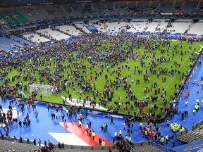 This is a Friday Nov. 13, 2015 file photo of spectators on the field at the Stade de France stadium Friday, Nov. 13, 2015 in Saint Denis, outside Paris. (AP Photo/Michel Euler, File)