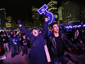 Toronto Blue Jays fans celebrate a two-run homerun by Jose Bautista in the eighth inning while watching the ALCS game six between the Blue Jays and the Kansas City Royals broadcasted at the "Bird's Nest" in Nathan Phillips Square in Toronto on Friday, Oct. 23, 2015. THE CANADIAN PRESS/Aaron Vincent Elkaim