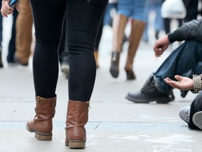 A woman panhandles in Toronto on Wednesday November 11, 2015. (Veronica Henri/Toronto Sun)