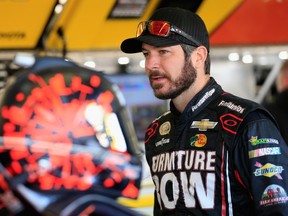 Martin Truex Jr., driver of the #78 Furniture Row/Visser Precision Chevrolet, stands in the garage area during practice for the NASCAR Sprint Cup Series Quicken Loans Race for Heroes 500 at Phoenix International Raceway on Nov. 14, 2015. (Chris Trotman/Getty Images/AFP)