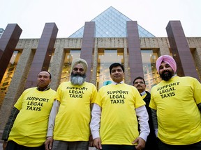 Taxi drivers pose for a photo outside City Hall, in Edmonton, Alta. on Tuesday Nov. 17, 2015. Taxi drivers attending the Edmonton City Council ride share debate were told that they had to turn the shirt inside out. David Bloom/Edmonton Sun/Postmedia Network