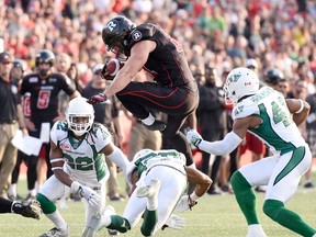 Ottawa Redblacks' Patrick Lavoie tries to break past Saskatchewan Roughriders players during second half CFL action in Ottawa on Aug. 30, 2015. (THE CANADIAN PRESS/Justin Tang)