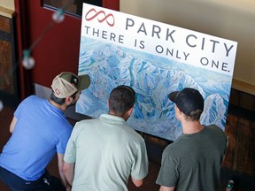 In this July 29, 2015, file photo, people look over the new Park City trail map following the Vail Resorts announcement that it is combining Park City Mountain Resort and Canyons Resort in Park City, Utah.  (AP Photo/Rick Bowmer, File)
