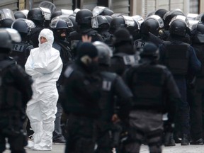 Members of French special police forces of the Research and Intervention Brigade (BRI) and forensic experts are seen near a raid zone in Saint-Denis, near Paris, France, on Nov. 18, 2015, during an operation to catch fugitives from Friday night's deadly attacks in the French capital. (REUTERS/Christian Hartmann)