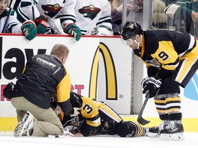 Pittsburgh Penguins defenceman Olli Maatta (3) is attended to by trainer Chris Stewart (left) as teammate Pascal Dupuis (9) looks on during NHL play against the Minnesota Wild at the CONSOL Energy Center. (Charles LeClaire/USA TODAY Sports)
