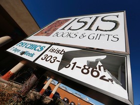 A panel of the sign outside Isis Books and Gifts store is broken Wednesday, Nov. 18, 2015, in Englewood, Colo.  Harrison and his wife, Karen, say that the New Age bookstore has been targeted by vandals because of the shop's name. The owner says the store is named after the Egyptian goddess Isis, and says the most recent vandalism is likely in response to Friday's terror attacks in Paris. (AP Photo/David Zalubowski)