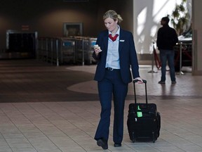 An Air Canada flight attendant walks through the terminal at the Halifax airport on Sept. 20, 2011. Air Canada and CUPE say the airline's flight attendants have approved a 10-year agreement reached with the carrier last month.The union said in a statement that the agreement was accepted by a narrow margin, but did not provide a voting margin. (THE CANADIAN PRESS/Andrew Vaughan)