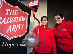 Salvation Army staff members Pamelina Chang, left, and Leslie Stuart, right, donate money to a Salvation Army kettle during the organization's Christmas Kettle Campaign kickoff at the Westin Hotel in Edmonton, Alta., on Wednesday, Nov. 18, 2015. Codie McLachlan/Edmonton Sun/Postmedia Network