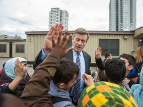 Mayor John Tory offers a high-five as he's mobbed by students for autographs and selfies as he visits Grenoble Public School. A Muslim mother had been attacked nearby. (Ernest Doroszuk/Toronto Sun)
