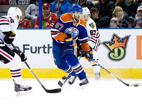 The Edmonton Oilers' Benoit Pouliot (67) battles the Chicago Blackhawks'  Marcus Kruger (16) and Tanner Kero (67) during first period NHL action at Rexall Place, in Edmonton, Alta. on Wednesday Nov. 18, 2015. David Bloom/Edmonton Sun/Postmedia Network