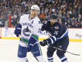 Nov 18, 2015; Winnipeg, Manitoba, CAN; Winnipeg Jets forward Andrew Ladd (16) battles with Vancouver Canucks left wing Daniel Sedin (22) during the first period at MTS Centre. Mandatory Credit: Bruce Fedyck-USA TODAY Sports