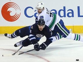 Winnipeg Jets center Bryan Little is tripped up by Vancouver Canucks left winger Daniel Sedin during NHL hockey in Winnipeg, Man. Wednesday November 18, 2015.
Brian Donogh/Winnipeg Sun/Postmedia Network