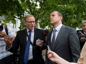 Chris Woodcock, former director of issues management in the Prime Minister's Office, is scrummed by reporters, including CTV's Robert Fife, who broke the story on the Duffy senate expenses scandal, as he leaves the courthouse in Ottawa following his second day of testimony at the trial of Sen. Mike Duffy, a former Conservative caucus member, on Tuesday, Aug. 25, 2015. THE CANADIAN PRESS/Justin Tang