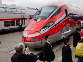 People take pictures of a Frecciarossa 1000 high-speed train by Bombardier Transportation at the InnoTrans railway technology trade fair in Berlin, in this file photo taken Sept. 25, 2014.  REUTERS/Thomas Peter/Files