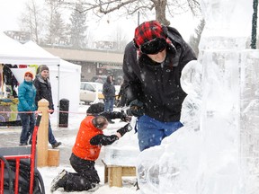 A sudden downfall of snow didn't hamper the spirits of ice carvers Joe Martin, foreground, and Norm Flann during the annual competition at the Canmore Winter Carnival on Saturday, Feb. 9, 2013. RUSS ULLYOT/Postmedia Network
