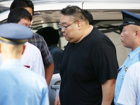 This picture taken on September 2, 2015 shows former Japanese sumo stable master Kazuyuki Yamamura (C) at a police station in Tokyo after he was arrested for the alleged abuse against the man hired as a driver.  Yamamura has admitted to abusing an assistant, including beating him with a bat, stuffing a towel in his mouth and forcing him to eat a full wasabi container. Yamamura, who once headed the stable of record-breaking Mongolian sumo wrestler Hakuho, told a Tokyo court on November 16 that he had repeatedly hit his former assistant with a metal bat.  AFP PHOTO / JIJI PRESS    JAPAN OUT