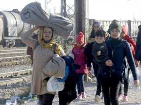 Migrants and refugees walk towards the border with Serbia, after arriving at the transit center for refugees near the village of Tabanovce, in northern Macedonia, on Thursday. (AP Photo/Boris Grdanoski)