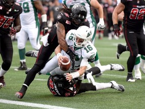 Ottawa Redblacks' Damaso Munoz, top, and Aston Whiteside take down Saskatchewan Roughriders' Brett Smith dring a CFL game on Sunday, August 30, 2015. THE CANADIAN PRESS/Justin Tang