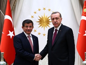 Turkey's Prime Minister Ahmet Davutoglu  left, and President Recep Tayyip Erdogan shake hands before a meeting in Ankara, Turkey, Tuesday, Nov. 17, 2015. Erdogan has re-appointed Davutoglu to form a new government after his party's victory in elections on Nov.1.(Presidential Press Service/Pool Photo via AP)