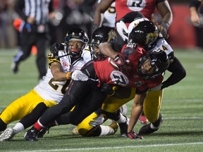 Ottawa Redblacks' running back William Powell is brought down by three Hamilton Tiger-Cats during second half CFL action, in Ottawa, on Saturday, Nov. 7, 2015. (THE CANADIAN PRESS/Adrian Wyld)