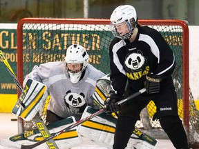 Alex Poznikoff, shown here at practice Wednesday with goalie Dayna Owen, has seven goals and a plus-6 rating in a dozen games for the Pandas this season. (David Bloom, Edmonton Sun)