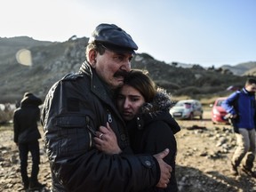 A man hugs her daughter after arriving on the Greek island of Lesbos along with other migrants and refugees, on November 17, 2015, after crossing the Aegean Sea from Turkey. The Canadian government is preparing for the arrival of 25,000 Syrian refugees, who may live in temporary camps upon arrival. AFP PHOTO/BULENT KILIC