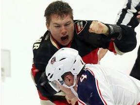Ottawa Senators' Curtis Lazar (27) fights with Columbus Blue Jackets' Kevin Connauton (4) during first period NHL hockey action in Ottawa Thursday, November 19, 2015. THE CANADIAN PRESS/Fred Chartrand