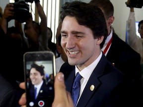 Canadian Prime Minister Justin Trudeau smiles at fans after speaking at a news conference at the end of the 21-member Asia-Pacific Economic Cooperation (APEC) summit in Manila November 19, 2015.  REUTERS/Erik De Castro