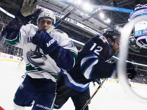 Vancouver Canucks' Jake Virtanen (18) and Winnipeg Jets' Drew Stafford (12) collide during second period NHL action in Winnipeg on Wednesday, November 18, 2015.