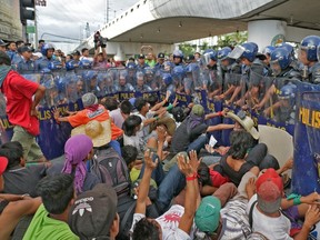 Filipino laborers clash with police in the Makati section of Manila on Nov. 16, 2015 during protests to raise issues as world leaders arrive for the Asia-Pacific Economic Cooperation (APEC) Summit this week.  (AFP PHOTO/JOSEPH AGCAOILI)