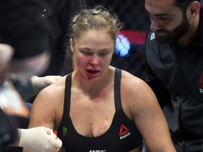 Ronda Rousey is treated by a medical staff member after being knocked out by Holly Holm in their UFC 193 bantamweight title fight in Melbourne, Australia, Sunday, Nov. 15, 2015. Holm pulled off a stunning upset victory over Rousey in the fight, knocking out the women's bantamweight champion in the second round with a powerful kick to the head Sunday.  (AP Photo/Andy Brownbill)