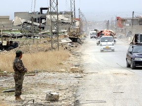 Yazidi people in vehicles loot the area of Sinjar, Iraq November 16, 2015. Before it was overrun by Islamic State, Sinjar and the surrounding villages were home to about 200,000 people, mainly Kurdish and Arab Muslims - both Sunni and Shi'ite - as well as Christians and Yazidis, a faith that combines elements of several ancient Middle Eastern religions. Now the town is largely deserted. But in a row of houses used by Islamic State fighters, there were signs of recent occupation: a smell of rotting food, and foam mattresses and pillows laid on the floor. Picture taken November 16 2015. REUTERS/Azad Lashkari