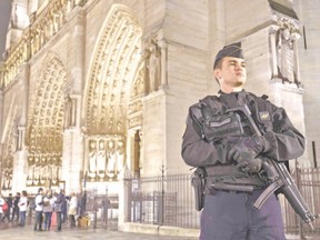 A French gendarme stands on guard in front of the Notre-Dame cathedral in Paris. France revealed this week it will spend an extra 600 million euros next year to ramp up security after the Paris attacks. (Joel Saget/AFP Photo)