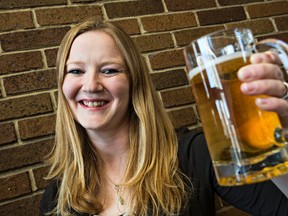 Stephanie Weizenbach, outreach coordinator with Edmonton and Area Land Trust, poses with a beer at the group's office in Edmonton, Alta., on Friday, Nov. 20, 2015. Starting next February, customers can pick up a unique Oatmeal Brown Ale from Phillips Brewing Co. (note: not the pictured beer) with an estimated $10,000 in proceeds going towards the Edmonton and Area Land Trust (EALT) to help support the conservation of local nature. The EALT is the 2016 Alberta winner of the B.C.-based crewing company's charitable Benefit Brew program. Codie McLachlan/Edmonton Sun