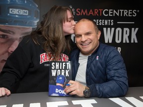 Tie Domi gets a kiss from one of his biggest fans, Alyssa Mahon, after he signed her copy of his book, Shift Work, in London. " The first game I ever saw (at age 8) was a Leafs game," she said. "Tie got in a fight and I've been hooked on hockey ever since." (Derek Ruttan/Postmedia Network)