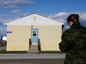 A member of the Canadian Armed Forces stands outside the cadet barracks at CFB Trenton. The barracks are being winterized to house Syrian refugees. A source tells the Toronto Sun reservists in Ontario are being offered refugee security duty. (Luke Hendry/Belleville Intelligencer/Postmedia Network)