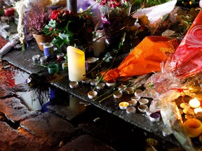 Flowers and candle tributes are placed in front of the Cosa Nostra restaurant in Paris.(AP Photo/Thibault Camus)
