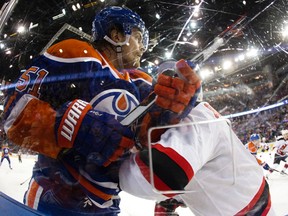 The Edmonton Oilers' Anton Lander (51) battles the New Jersey Devils' David Schlemko (8) in the corner during first period NHL action at Rexall Place, in Edmonton, Alta. on Friday Nov. 20, 2015. David Bloom/Edmonton Sun/Postmedia Network