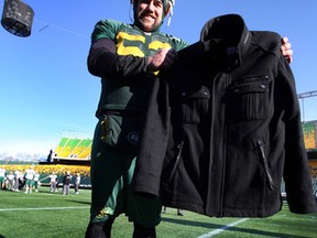 Ryan King holds a jacket during Friday's Edmonton Eskimos' practice at Commonwealth Stadium in Edmonton, Alta., on  Nov 20, 2015. The Eskimos and Goodwill are holding a clothing drive during the CFL West Final to benefit Albertans with physical and mental disabilities. Perry Mah/Edmonton Sun/Postmedia Network