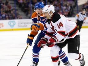 The Edmonton Oilers' Ryan Nugent-Hopkins (93) battles the New Jersey Devils' Adam Henrique (14) during first period NHL action at Rexall Place, in Edmonton, Alta. on Friday Nov. 20, 2015. David Bloom/Edmonton Sun/Postmedia Network