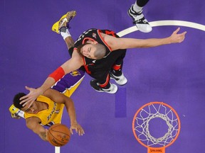 Los Angeles Lakers guard D'Angelo Russell, left, shoots as Toronto Raptors center Jonas Valanciunas, of Lithuania, defends during the first half of an NBA basketball game, Friday, Nov. 20, 2015, in Los Angeles. (AP Photo/Mark J. Terrill)