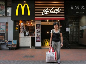 In this Friday, Nov. 20, 2015 photo, Mary Seow poses in front of a 24-hour McDonald’s branch where she began sleeping about four weeks ago after she noticed others doing it in Hong Kong. Seow, a Singaporean woman who went missing nearly five years ago, has been reunited with her son after her plight was reported in an Associated Press story about people who sleep at 24-hour McDonald's outlets in Hong Kong. (AP Photo/Vincent Yu)