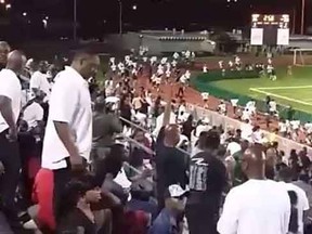 Fans and players flee a Miami high school stadium after gun shots ring out.